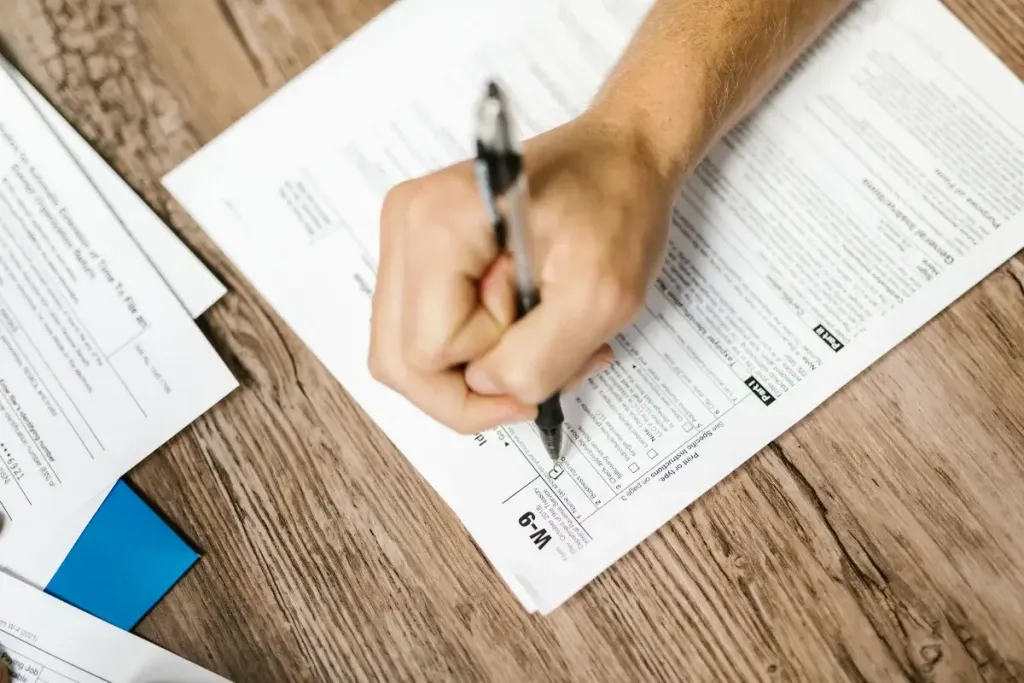 Mano che compila una scheda di certifcazione