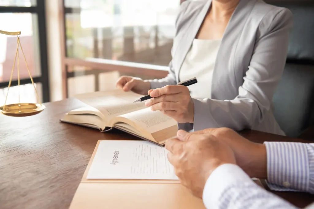 Nella foto sono presenti due persone sedute attorno un tavolo sul quale sono presenti dei libri