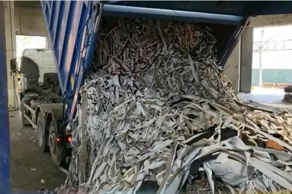 Nella foto è raffigurato un camion merci che sta scaricando le cimose, un particolare scarto composito termoplastico